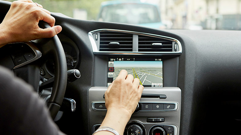 Person using the navigation systemm on their car dashboard