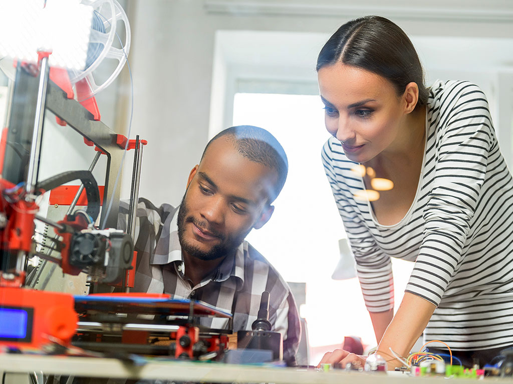 two young people working with technology