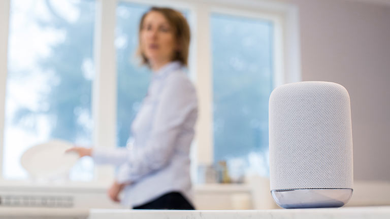 woman speaking near AI device