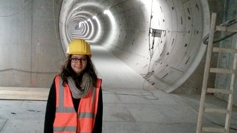 Young woman wearing safety gear standing in tunnel