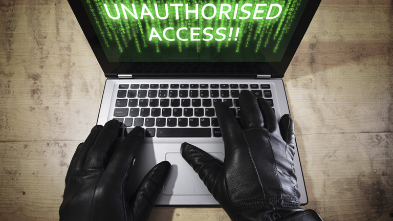 hands with black gloves breaking into a laptop