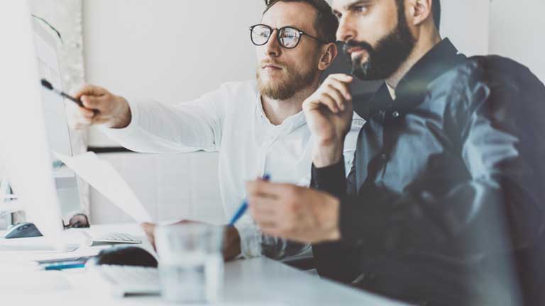 Two male colleagues reviewing a technical document Two male colleagues reviewing a technical document