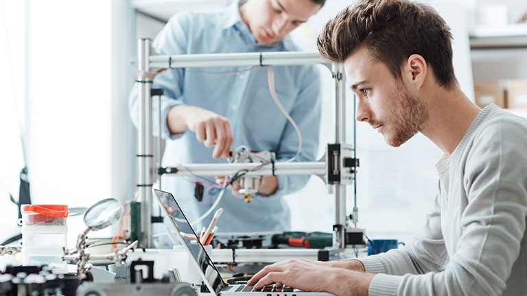 two young men working in lab on prototype