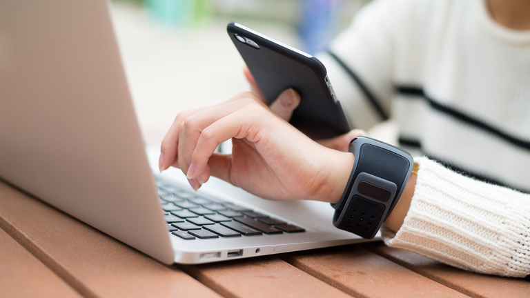 woman on laptop with smart phone and smart watch