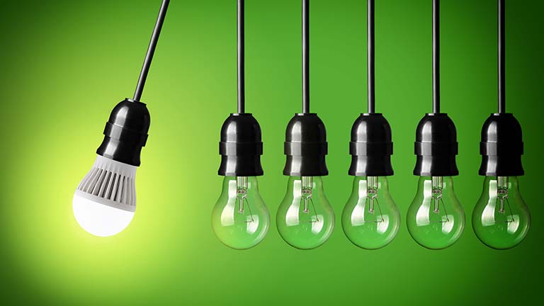 LED lightbulbs hanging in a row on green background