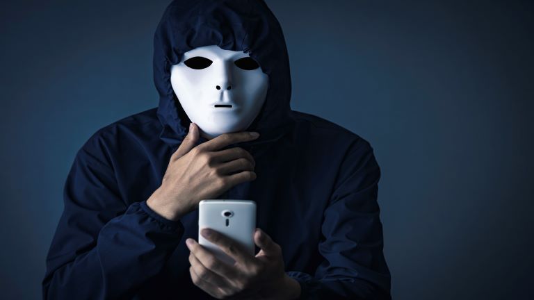 person wearing mask, holding smartphone