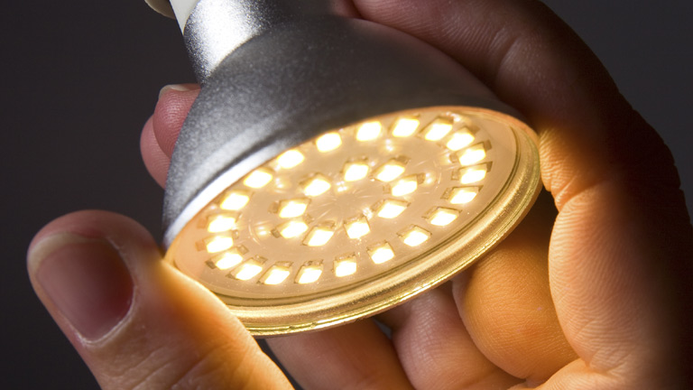 hand holding an lit LED bulb