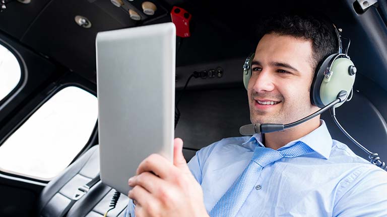 pilot in the cockpit looking at iPad