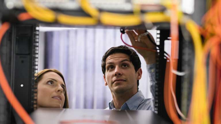 Man and woman making an adjustment to hardware wiring
