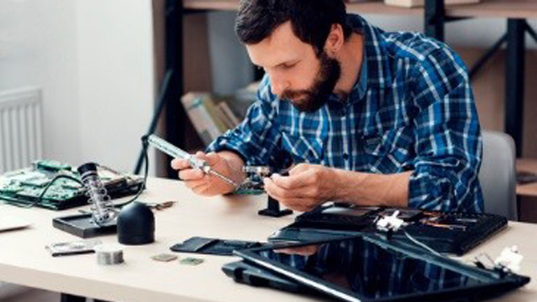 Man using a soldering tool to work on a circuit board