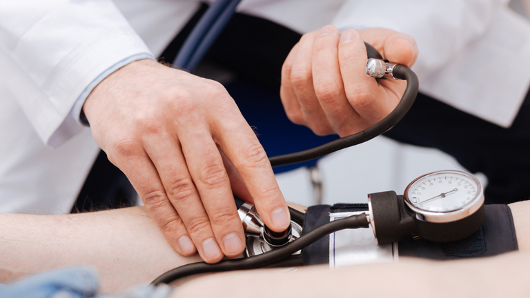 doctor taking patient's blood pressure