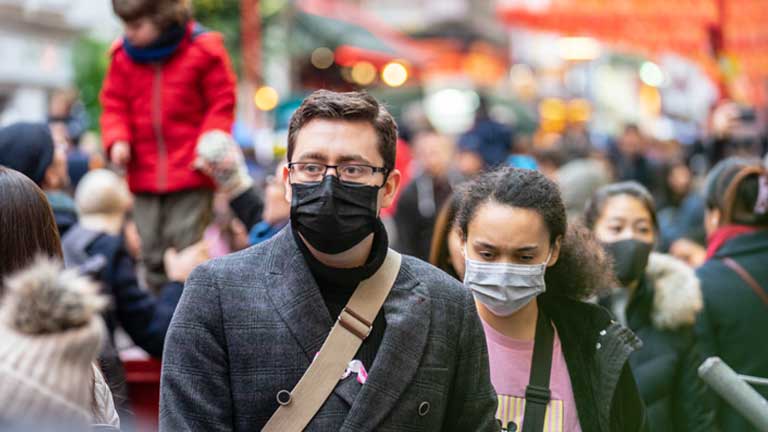 Man and woman in a crowd wearing medical masks