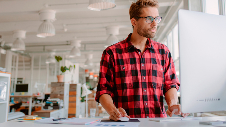 man in red flannel shirt at workstation