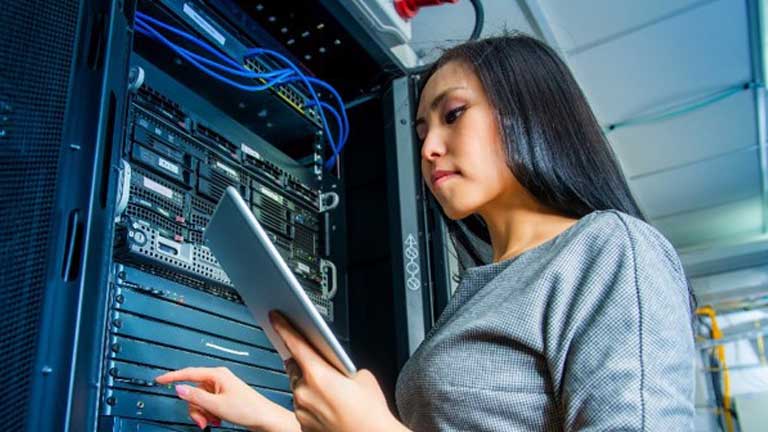 Woman using tablet and working in data center