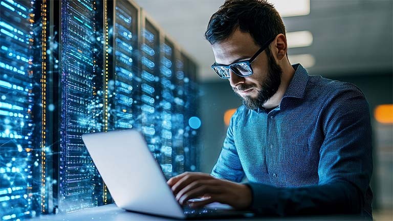 man using laptop computer in data center