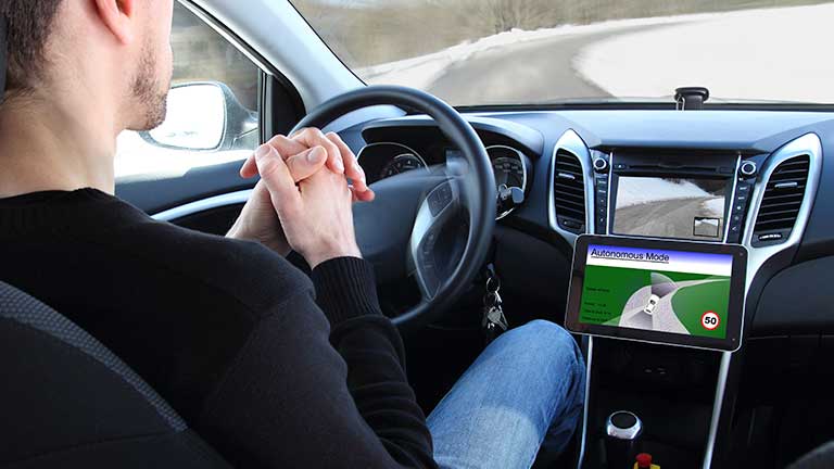 man in dirverless car with hands off the wheel