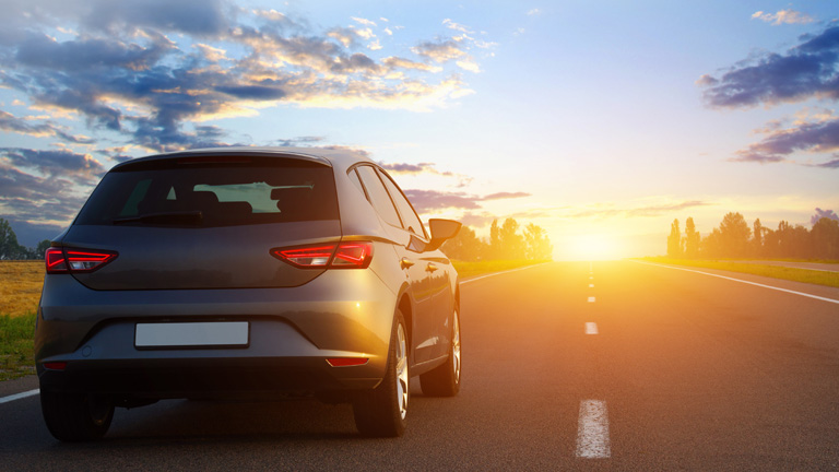 smart car driving towards a sunset