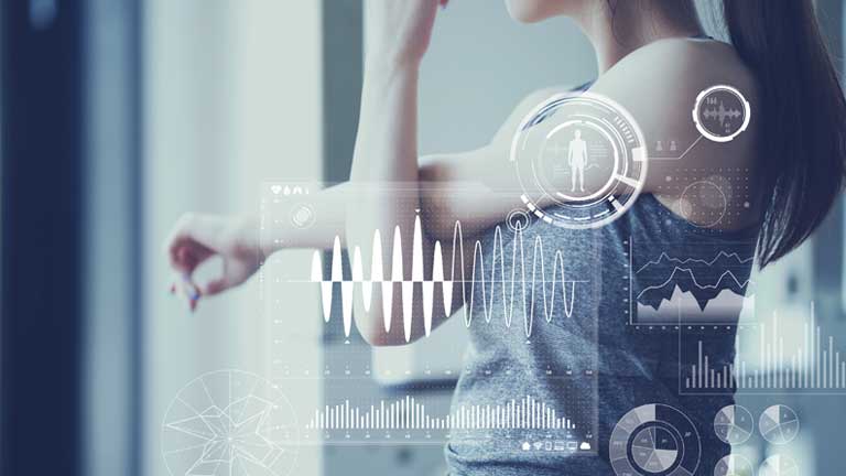 A woman sitting and eating a snack while she is being monitored by a wearable device