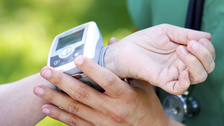 nurse checking person wearing health monitoring system on wrist