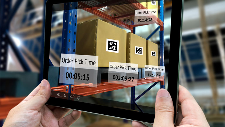 Person in a warehouse checking shipping status via tablet