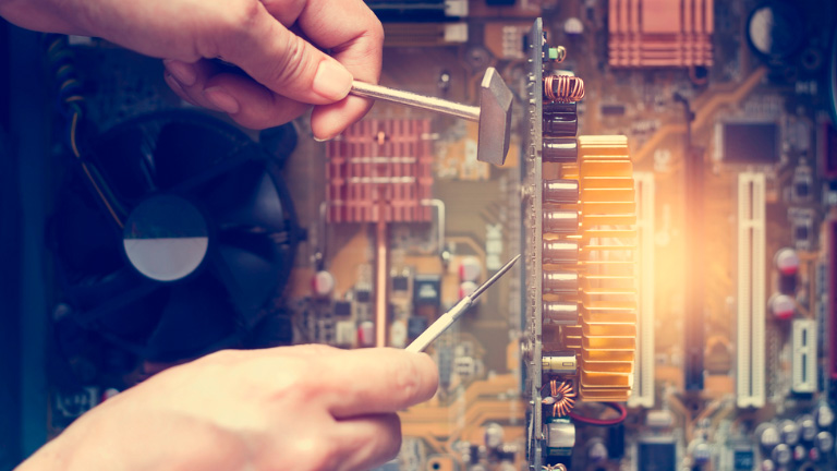 person inserting probes into computer board