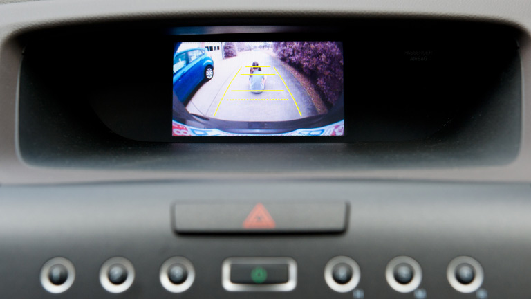 rear view camera on car dash with image of child riding a toy